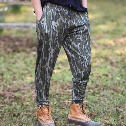 Men’s Mossy Oak camouflage joggers with performance stretch, buttery soft fabric, athletic fit, and tapered leg, featuring deep pockets and elastic drawstring waistband.  