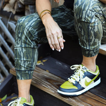 Model wearing women’s joggers in Mossy Oak camouflage and Nike sneakers to showcase athleisure wear and styling flexibility. 