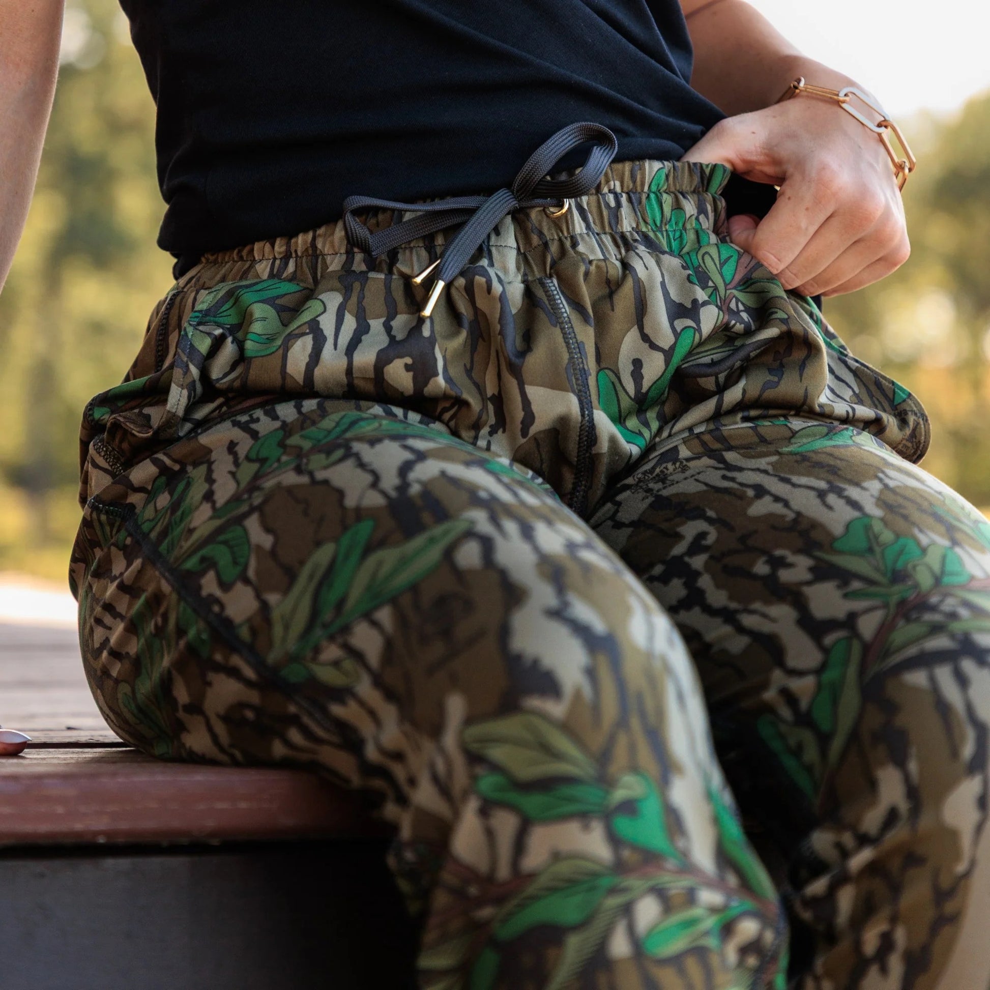 Close-up of gold drawstring end caps and grommet details on women’s Mossy Oak camo joggers.  