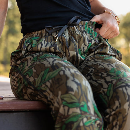 Close-up of gold drawstring end caps and grommet details on women’s Mossy Oak camo joggers.  