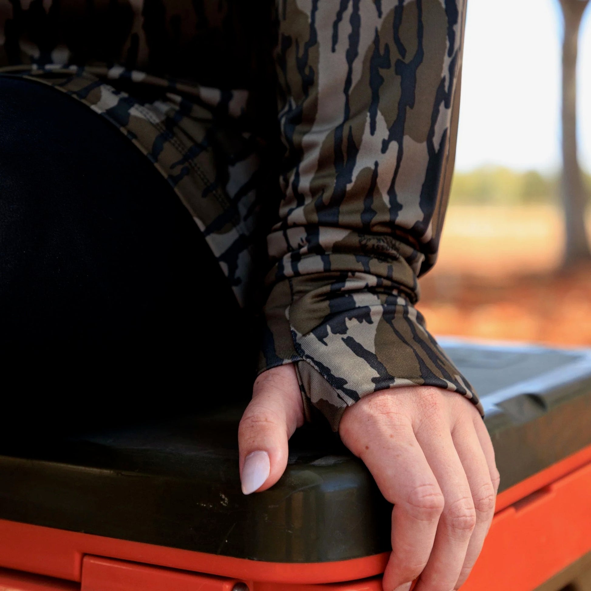 Women’s camouflage performance pullover sleeve detail with built-in thumb hole for active outdoor and athleisure use