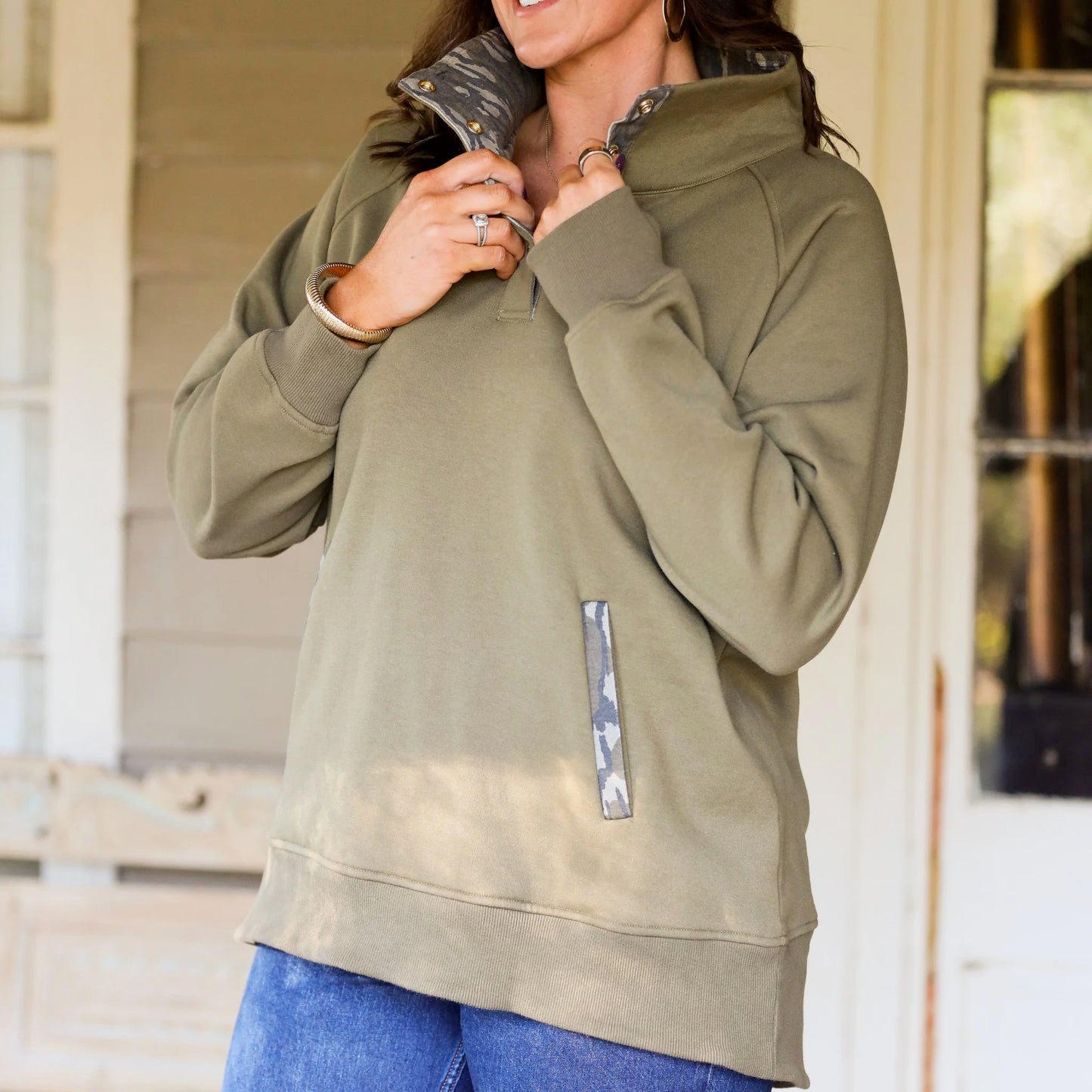 Women wearing an olive quarter-snap pullover featuring Mossy Oak Bottomland camo details, styled for every day outdoor lifestyle wear.  