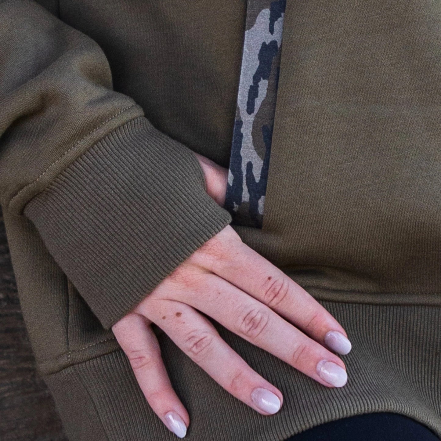 Close up detail shot of pocket placket in Mossy Oak Bottomland on a women’s quarter-snap pullover. 